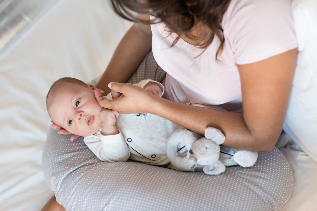 Mother with newborn baby in the nursing pillow